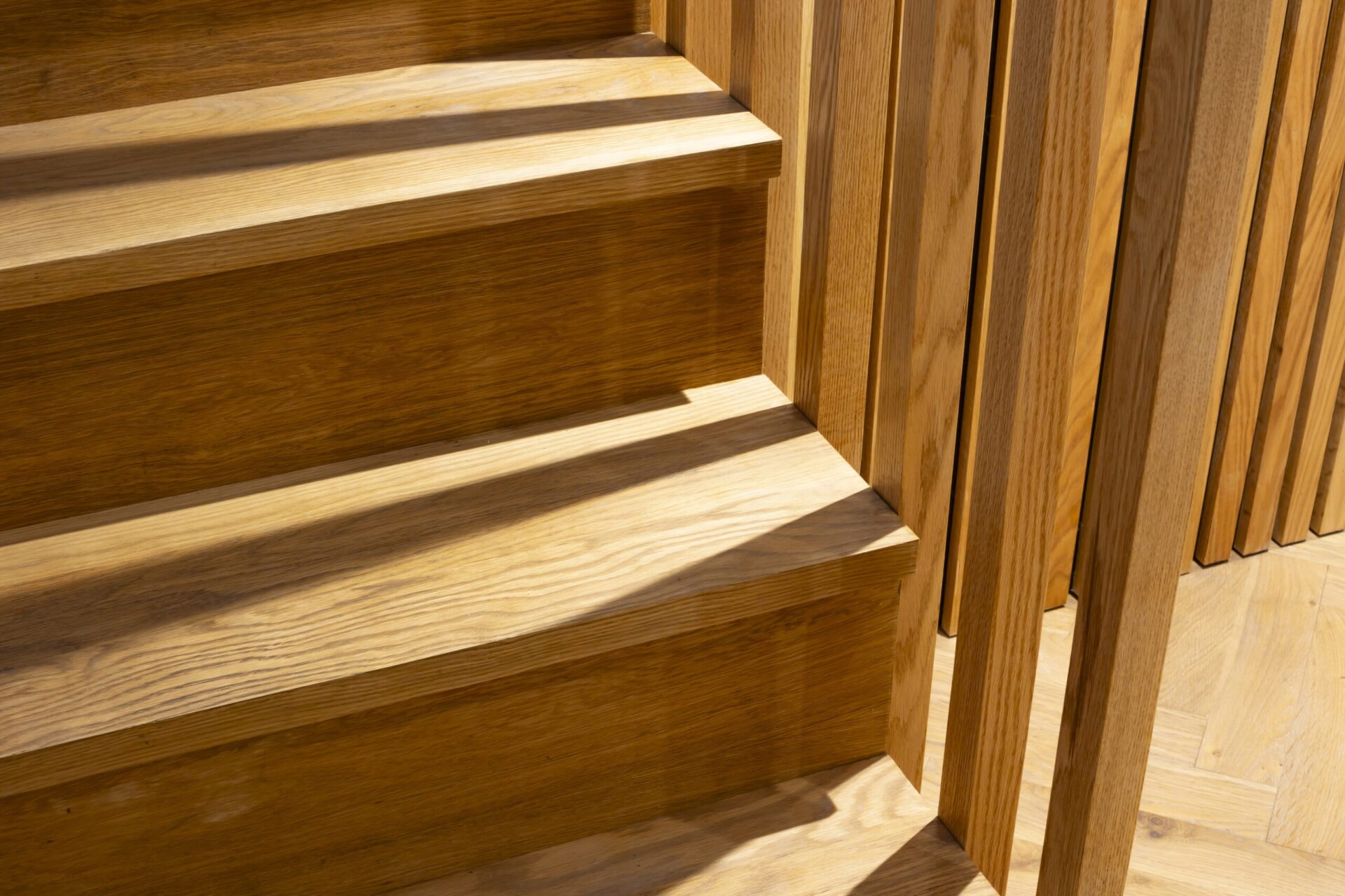 Close-up of an oak staircase with wooden spindles in warm natural light