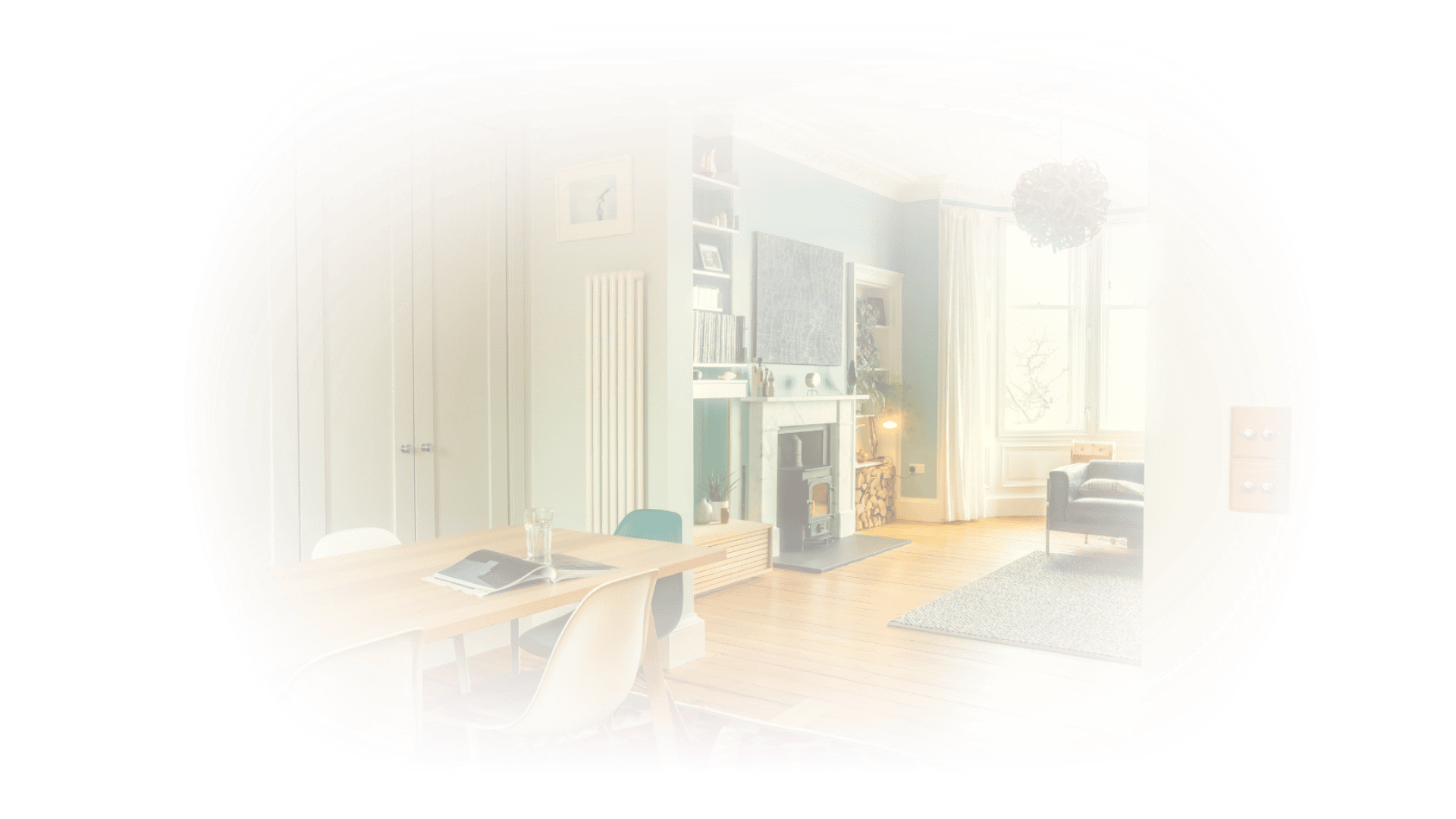 Bright renovated living room with a fireplace, large windows and wooden flooring